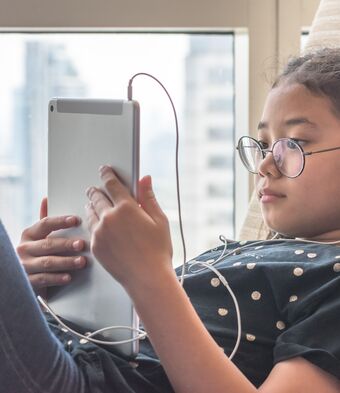 Girl on ipad with headphones in