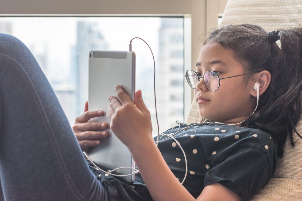 Girl on ipad with headphones in