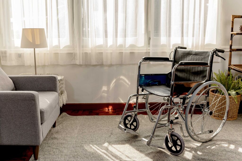 Empty wheelchair by hospital sofa
