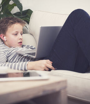 Young boy on laptop online gambling