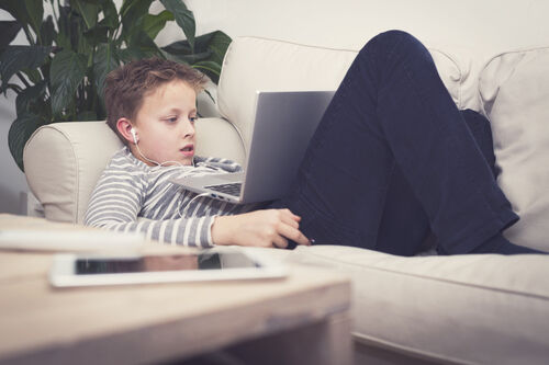 Young boy on laptop online gambling