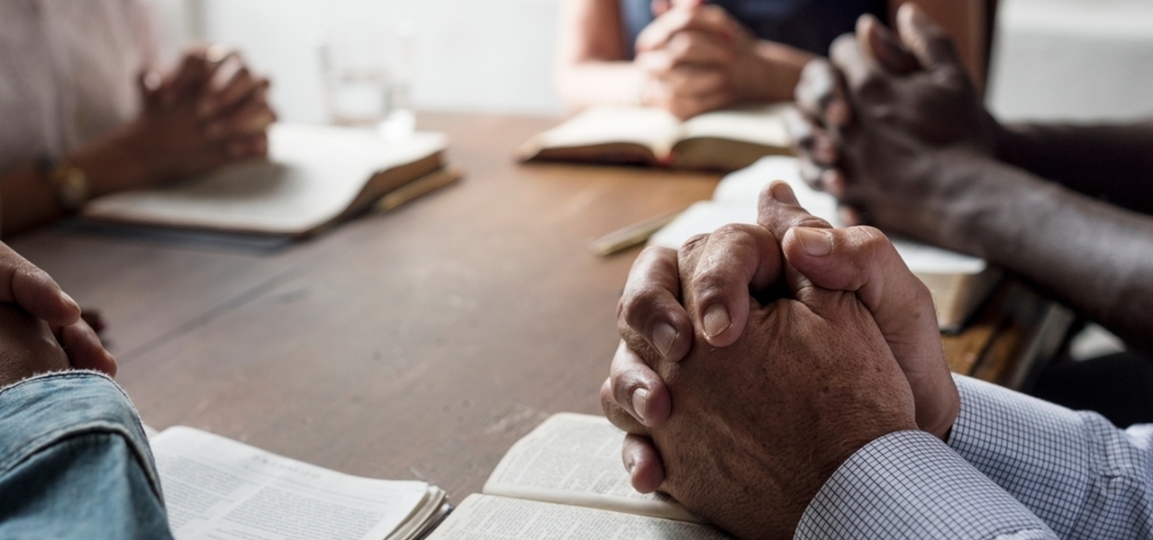 Prayer group bibles hands