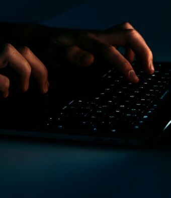 Hands typing on dark keyboard