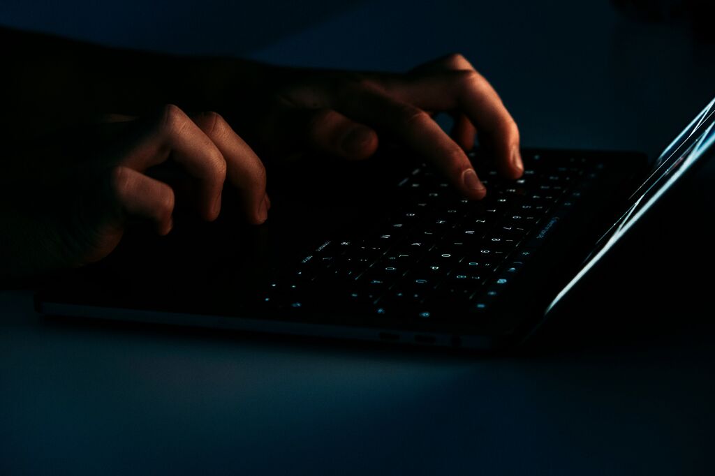 Hands typing on dark keyboard